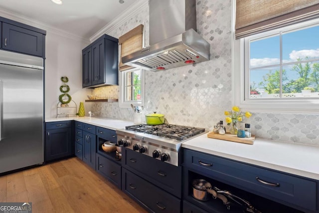 260 Jasmine Garden Way, Alpharetta, GA 30009 - kitchen with appliances with stainless steel finishes, wall chimney exhaust hood, light wood-style flooring, backsplash, and blue cabinets