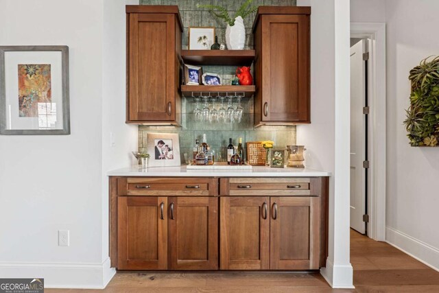 260 Jasmine Garden Way, Alpharetta, GA 30009 - bar featuring baseboards, tasteful backsplash, light wood-style floors, and a dry bar