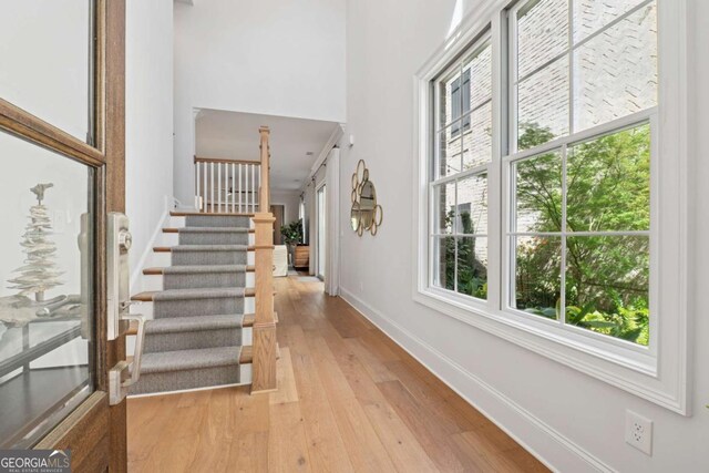 260 Jasmine Garden Way, Alpharetta, GA 30009 - foyer entrance with stairway, light wood-style floors, a towering ceiling, and baseboards