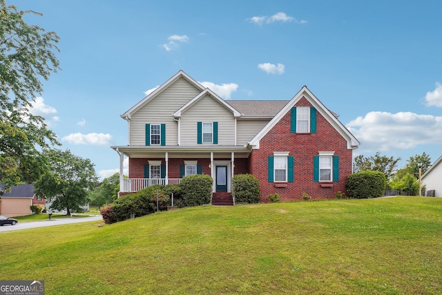 traditional-style home featuring a porch, a front lawn, and brick siding