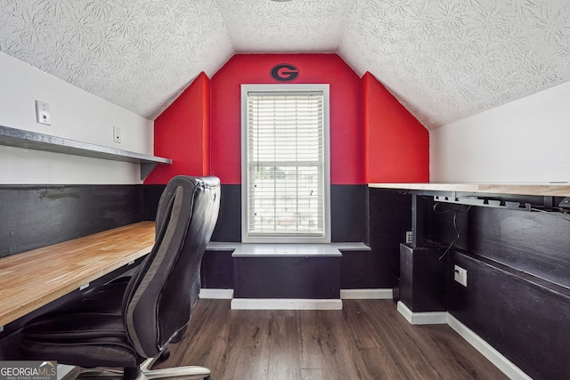 office space featuring a textured ceiling, baseboards, vaulted ceiling, and wood finished floors