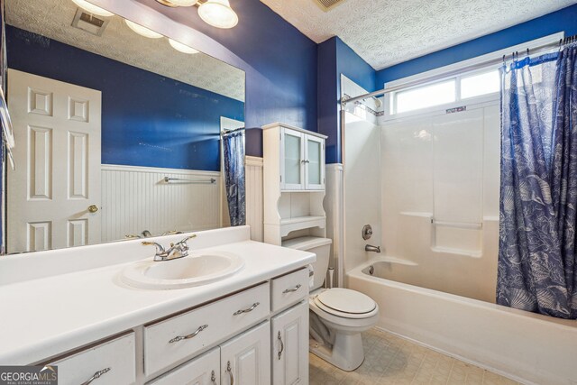 full bath with vanity, visible vents, wainscoting, shower / bath combination with curtain, and toilet