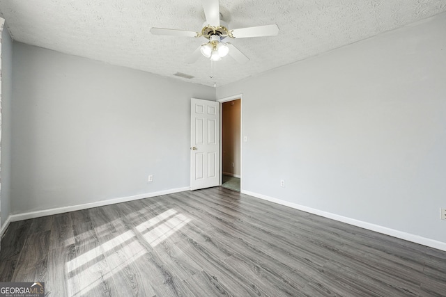 spare room featuring baseboards, a ceiling fan, wood finished floors, and visible vents