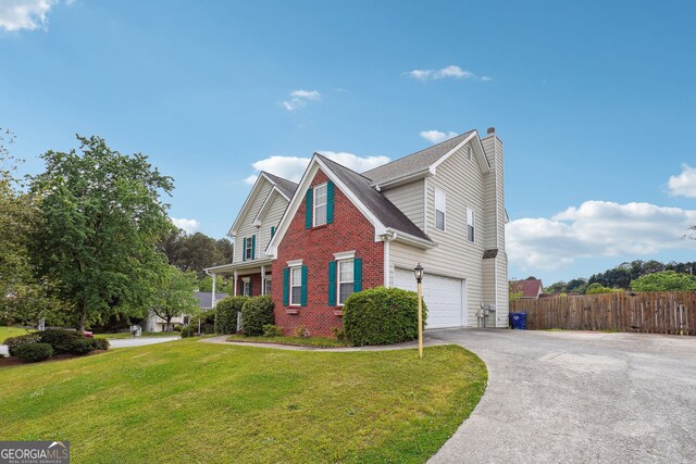 view of front facade with a chimney, fence, a front lawn, concrete driveway, and an attached garage