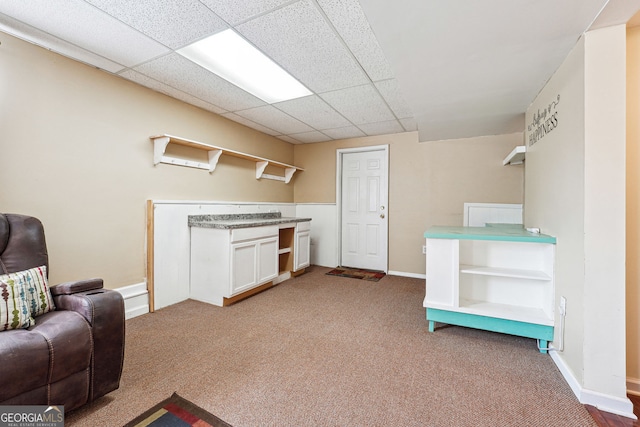 interior space featuring baseboards and a drop ceiling