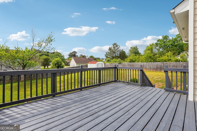 deck featuring a fenced backyard, an outbuilding, a yard, and a shed