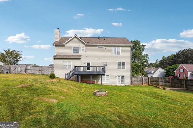 rear view of property featuring stairs, a fenced backyard, a wooden deck, and a chimney