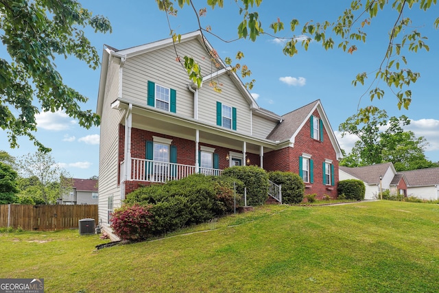 traditional-style house featuring brick siding, a front lawn, fence, and cooling unit
