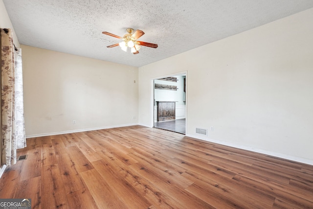 unfurnished room with visible vents, a ceiling fan, a textured ceiling, and light wood finished floors