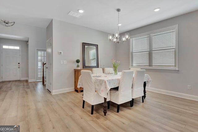 dining room with an inviting chandelier, visible vents, light wood-style floors, and baseboards
