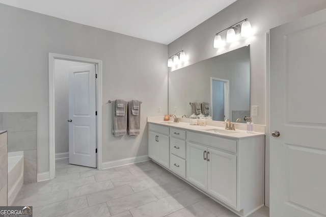 bathroom with a garden tub, double vanity, a sink, and marble finish floor