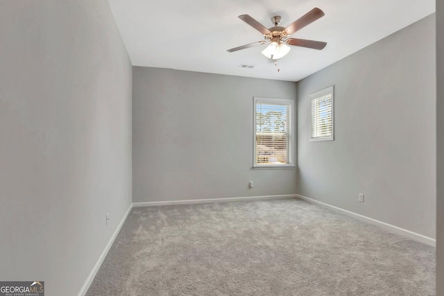 empty room featuring baseboards, visible vents, a ceiling fan, and carpet