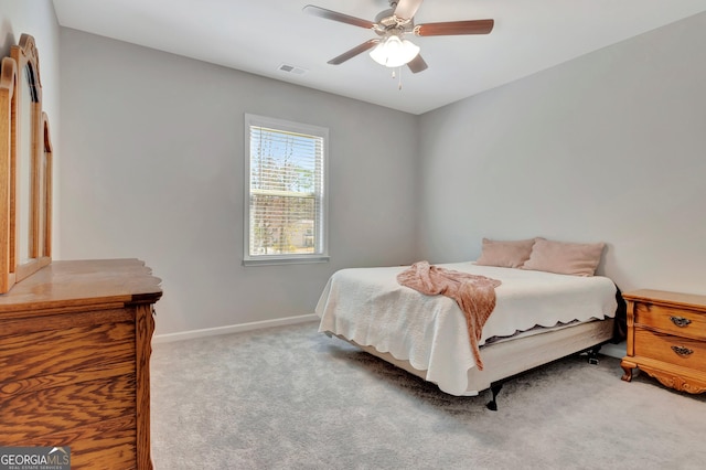 carpeted bedroom with visible vents, a ceiling fan, and baseboards