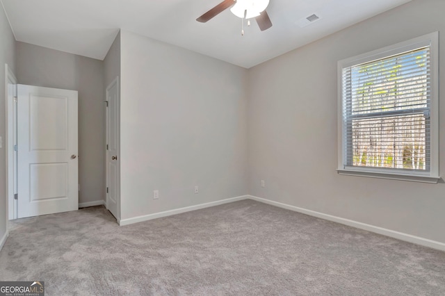 unfurnished room with carpet, visible vents, a ceiling fan, and baseboards