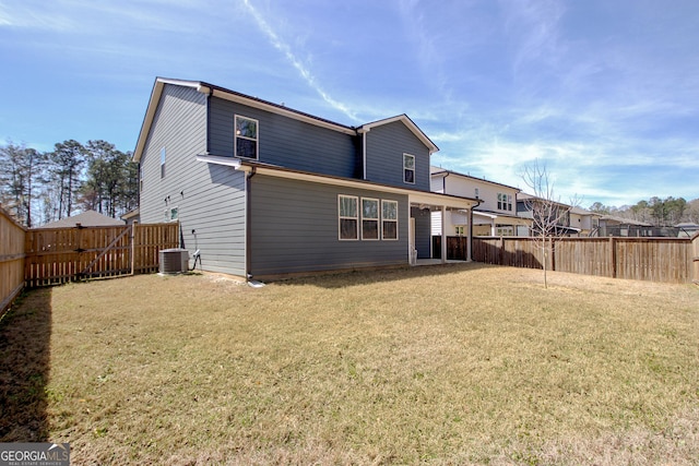 back of property with cooling unit, a yard, a fenced backyard, and a gate