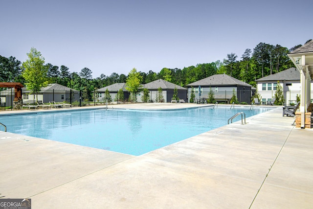 pool with a patio and fence
