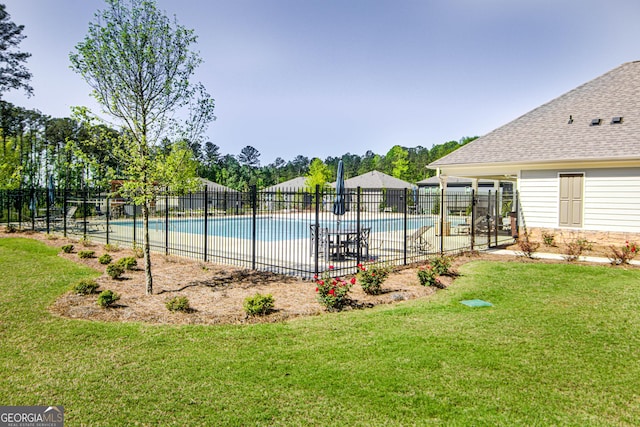 community pool featuring fence and a lawn