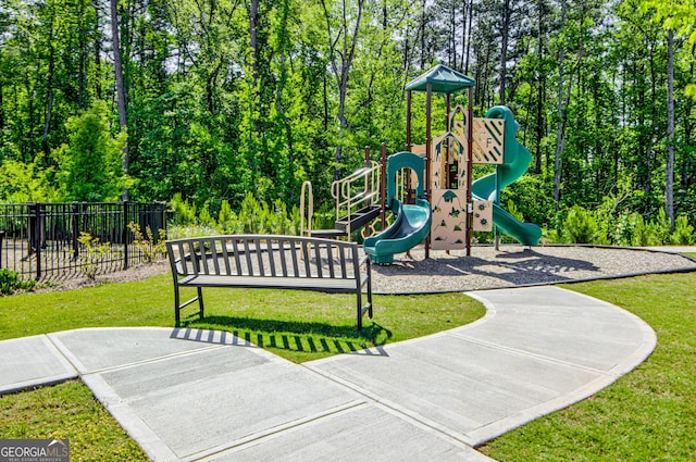 community play area featuring fence and a lawn