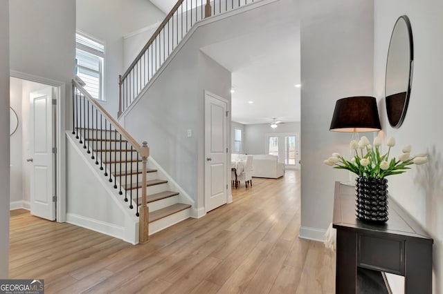 interior space featuring recessed lighting, ceiling fan, baseboards, a towering ceiling, and wood finished floors