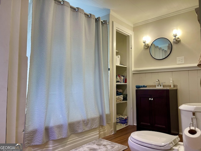 bathroom featuring wood finished floors, toilet, a sink, shower / tub combo, and crown molding