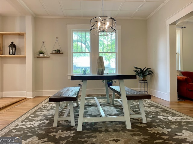 dining room featuring ornamental molding, an inviting chandelier, wood finished floors, and baseboards