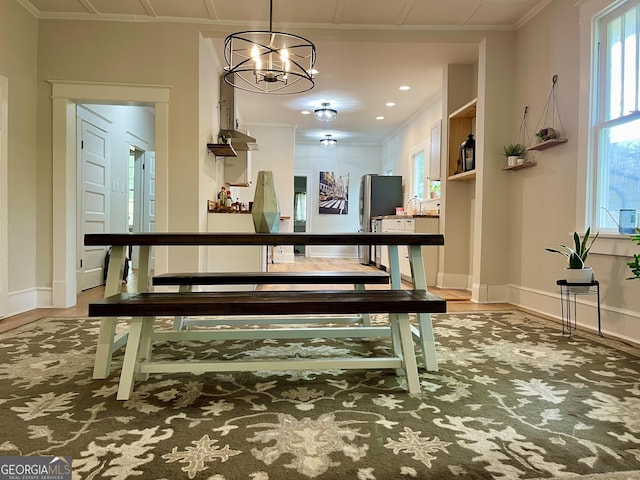 dining area with an inviting chandelier, wood finished floors, recessed lighting, and baseboards