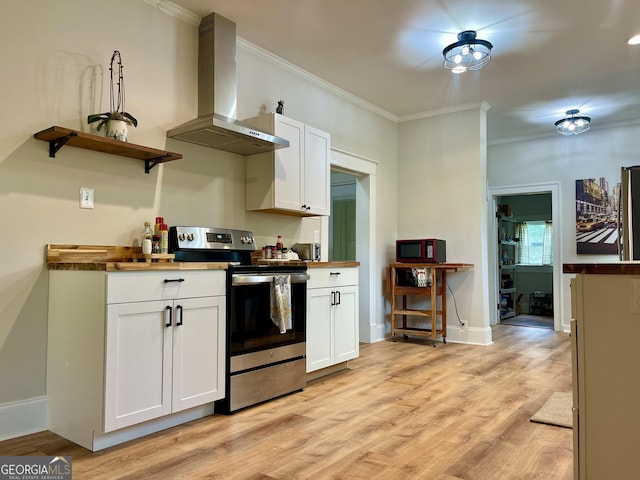 kitchen with crown molding, wall chimney exhaust hood, stainless steel range with electric stovetop, and white cabinetry