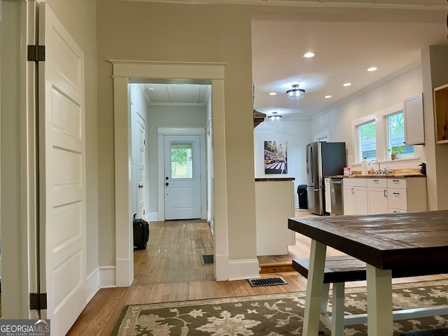 foyer entrance featuring light wood finished floors, recessed lighting, visible vents, baseboards, and ornamental molding