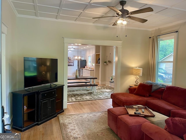 living room featuring wood finished floors, ceiling fan, and ornamental molding