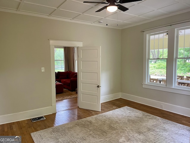 spare room featuring baseboards, visible vents, wood finished floors, and ceiling fan