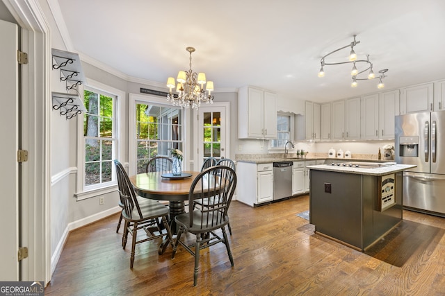 120 N Blf, Alpharetta, GA 30004 - kitchen featuring appliances with stainless steel finishes, a chandelier, white cabinetry, healthy amount of natural light, and crown molding