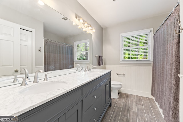 120 N Blf, Alpharetta, GA 30004 - bathroom featuring a wainscoted wall, toilet, double vanity, wood finished floors, and baseboards