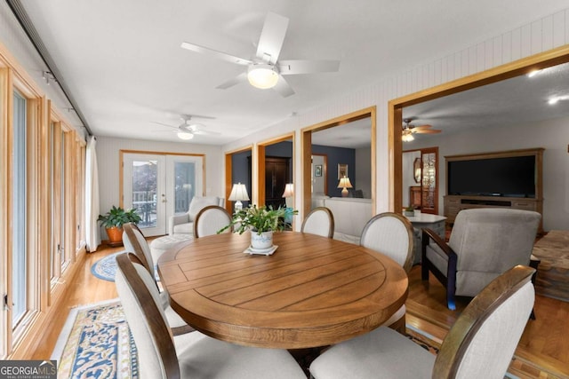 dining room featuring a ceiling fan, french doors, and light wood-style flooring