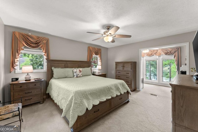bedroom with multiple windows, light carpet, and visible vents