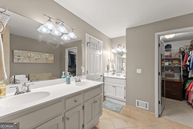 full bathroom with double vanity, a sink, a spacious closet, and visible vents
