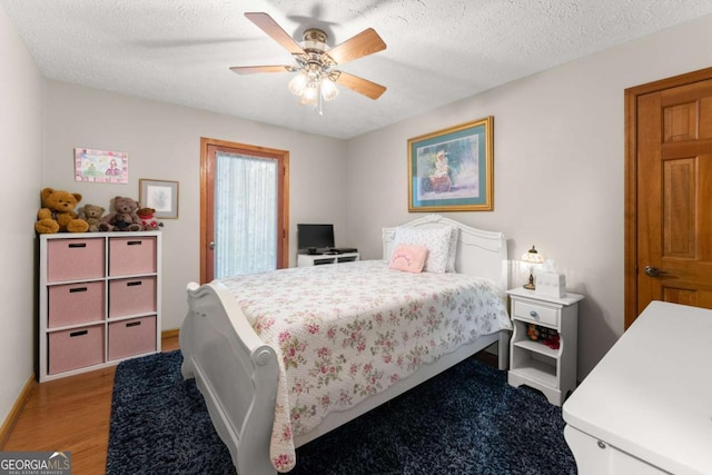 bedroom with a textured ceiling, a ceiling fan, light wood-style flooring, and baseboards
