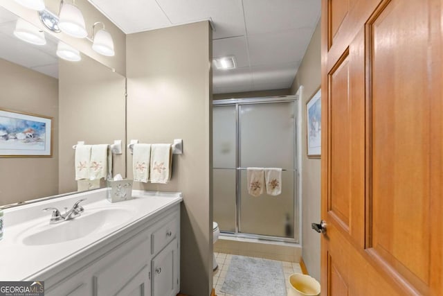 bathroom with tile patterned floors, a shower stall, toilet, and vanity