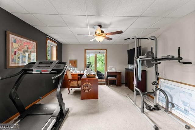 workout room featuring ceiling fan, a drop ceiling, and light colored carpet