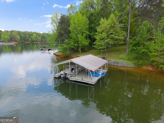 view of dock with boat lift, a water view, and a view of trees