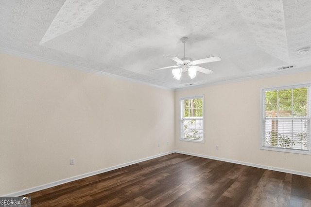 spare room with dark wood finished floors, baseboards, visible vents, a ceiling fan, and a textured ceiling
