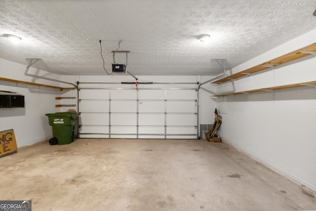 garage featuring a garage door opener and baseboards