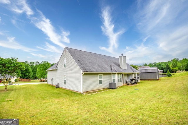 407 Gladiola Dr, Auburn, GA 30011 - rear view of property with a chimney, central AC unit, a yard, and roof with shingles