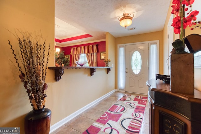 407 Gladiola Dr, Auburn, GA 30011 - foyer entrance with light tile patterned floors, crown molding, visible vents, a raised ceiling, and baseboards
