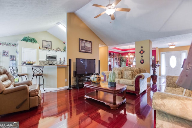 407 Gladiola Dr, Auburn, GA 30011 - living area featuring vaulted ceiling, wood finished floors, and ceiling fan with notable chandelier