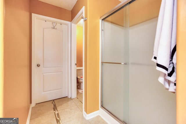 407 Gladiola Dr, Auburn, GA 30011 - bathroom with toilet, tile patterned flooring, a shower stall, and baseboards