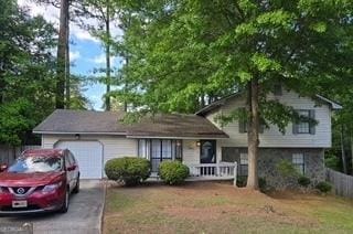 split level home with a garage, driveway, and a porch