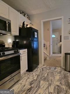 kitchen featuring stainless steel appliances and white cabinetry