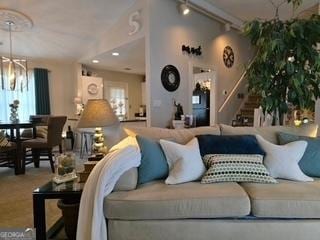 living area with rail lighting and a chandelier