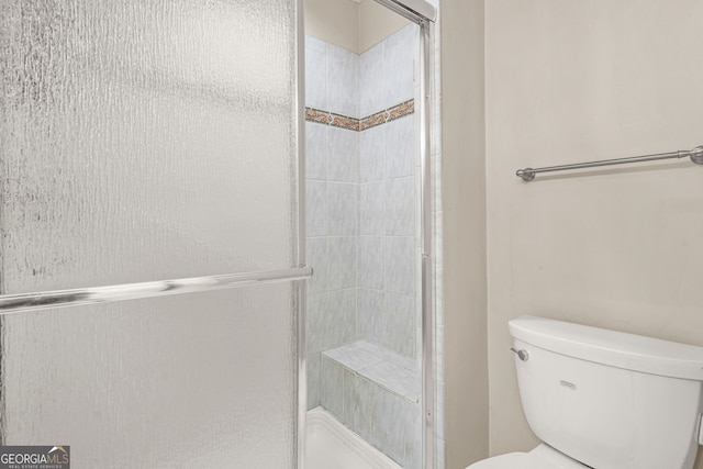 full bathroom with toilet and a shower stall