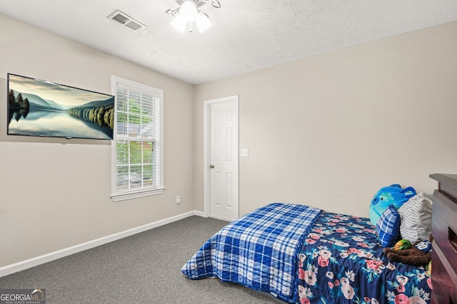 bedroom featuring a textured ceiling, visible vents, carpet, and baseboards